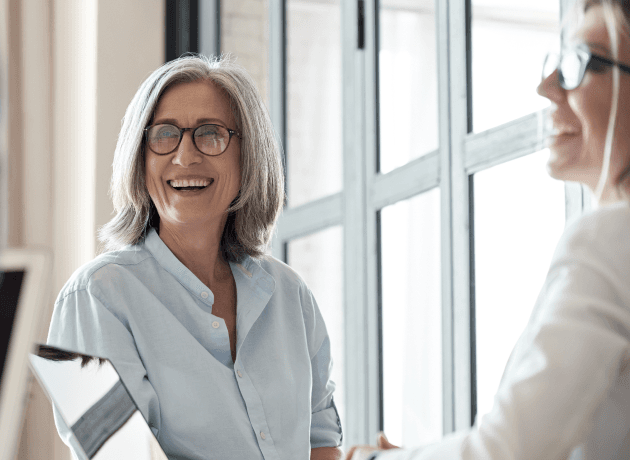 Two employees smiling in conversation